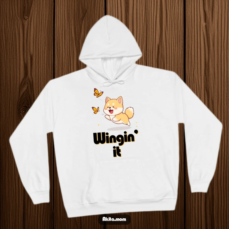 Funny Akita cub hoodie depicting a cute puppy in joyful pursuit of a butterfly, ideal for dog lovers and gift-givers.
